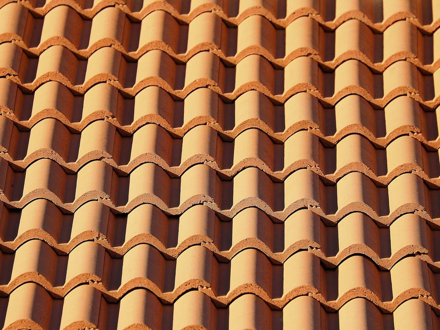 Nahaufnahme neuer orangeroter Tonziegel in gleichmäßigen Reihen